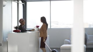 Woman speaking with employee at concierge desk