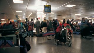 Image of travelers in line at an airport
