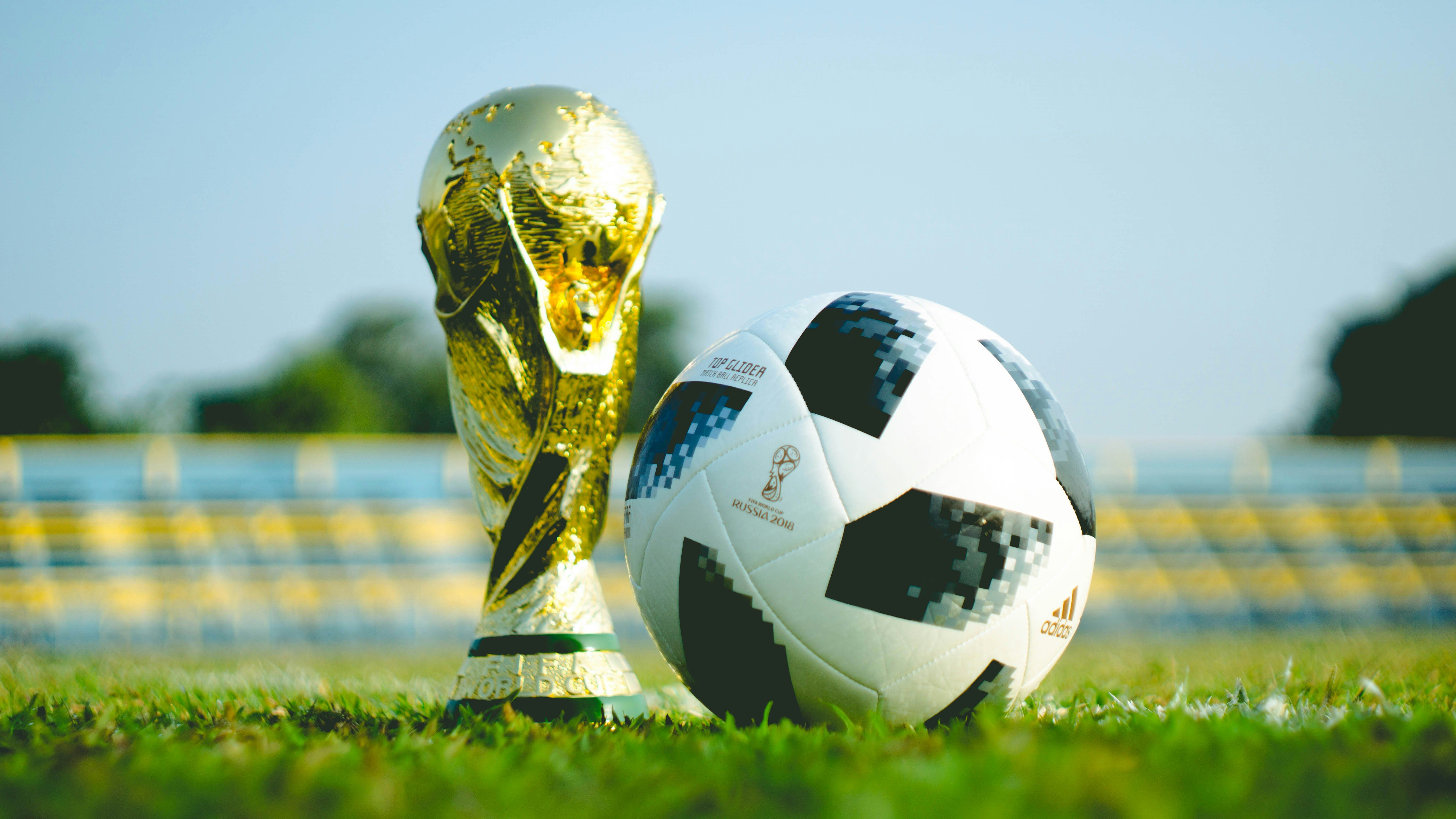World Cup Trophy Sitting next to a soccer ball